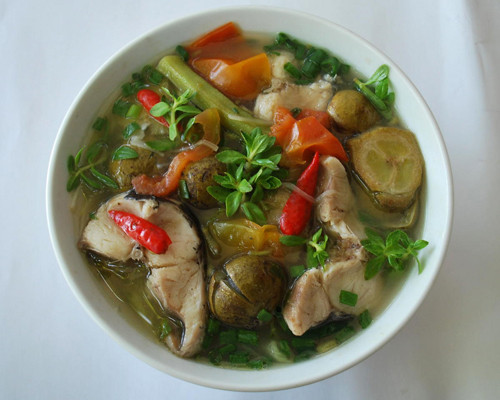 Đổ nước vào đun sôi. Sau khi nước sôi thì cho cá lóc đã rán vào. Đun thêm 15 phút cho cá ngấm gia vị rồi tắt bếp, rắc hành lá lên trên. Ảnh: baotintuc.vn.