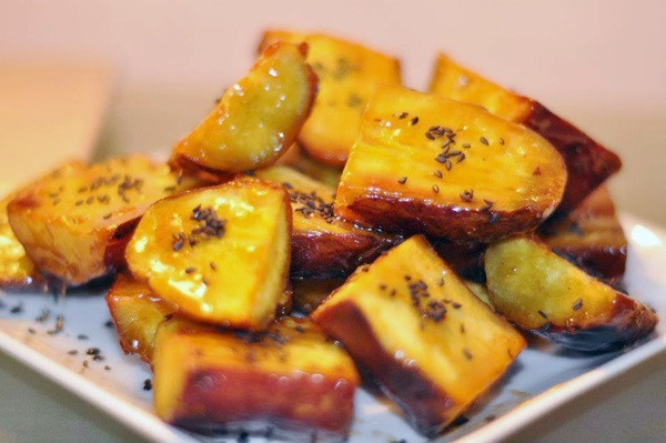 4. Khoai lang nướng mật ong. Nguyên liệu: Khoai lang, dầu oliu, mật ong, chanh dây, muối, tiêu, ớt bột. Khoai lang gọt vỏ, rửa sạch, xắt miếng vừa ăn. Ướp khoai với mật ong, dầu ô liu, chanh dây, trộn đều đề 15 phút. Cho khoai vào vỉ nưởng, sau đó rắc thêm chút tiêu, muối, bột ớt lên. Cho lên bếp than hoa nướng khoảng 30 phút, lật mặt khoai cho đều. Ảnh: ongmatcaonguyen.com.