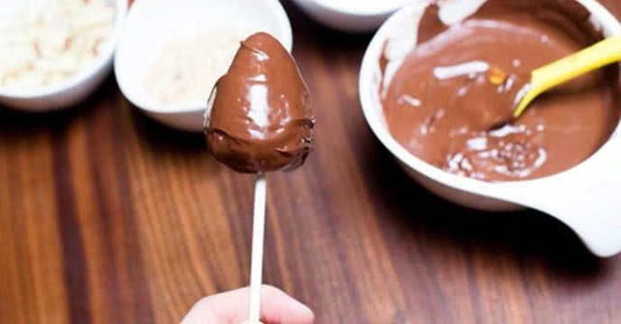 Sau đó nhúng nho vào chocolate, lăn qua khay hạnh nhân (đã giã dập) rồi đặt trên giấy nến. Nếu không có hạnh nhân, cũng có thể sử dụng hạt điều hoặc đậu phộng để thay thế. Ảnh: PasGo.vn.