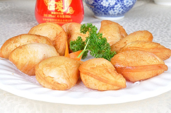 Lấy viên kem từ tủ lạnh ra cho vào nồi dầu nóng chiên với lửa lớn. Khi thấy viên kem vàng giòn là nhanh tay vớt kem ra. Kem chiên cho ra đĩa, trang trí thêm kem tươi và rắc thêm đường màu cho đẹp và hấp dẫn hơn. Ảnh: 6monngonmoingay.com.