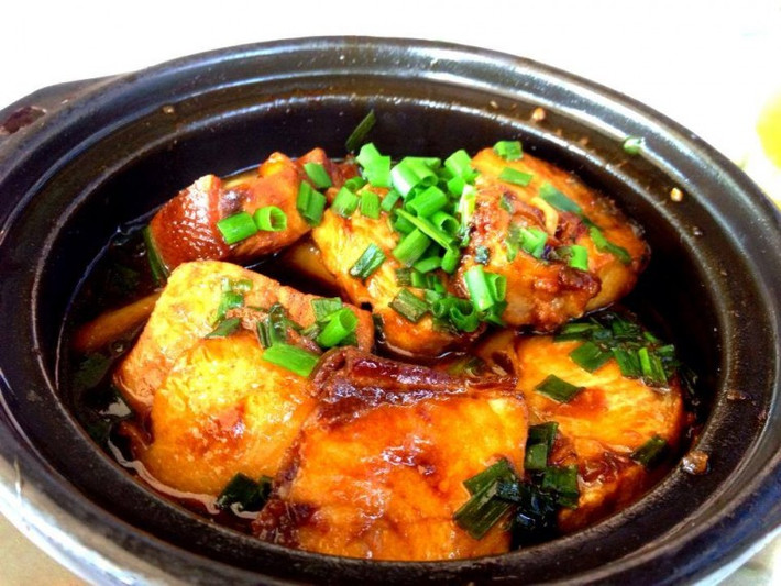 3. Cá kho nghệ. Nguyên liệu: Cá lóc (cá sặc, cá trèn...), nghệ, hành lá, ớt, nước mắm, đường, hạt nêm, dầu ăn, dừa tươi. Rửa sạch củ nghệ, giã nhuyễn. Làm sạch cá. Ướp cá với nghệ, nước mắm, đường, bột nêm, hành băm, ớt băm khoảng 15 phút cho ngấm. Cho cá vào nồi, cho nước dừa tươi, dầu ăn vào, đun trên lửa nhỏ cho đến khi nước kho sánh lại. Dọn cá ra đĩa, xếp vài lát nghệ lên trên. Ảnh: cakholangvudai.org.