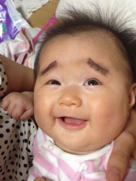 Một người mẹ sáng tạo dùng mi giả để gắn lông mày cho bé.