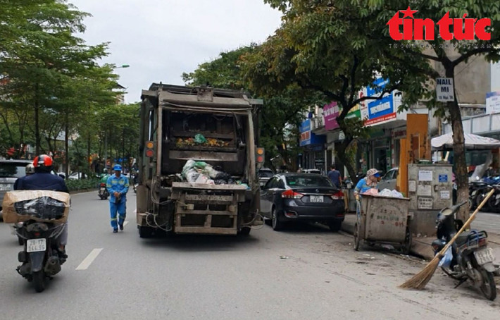 Xe chở rác sau khi lao vun vút trên đường Đào Tấn (quận Ba Đình), dừng lại tại điểm tập kết rác để thu gom.