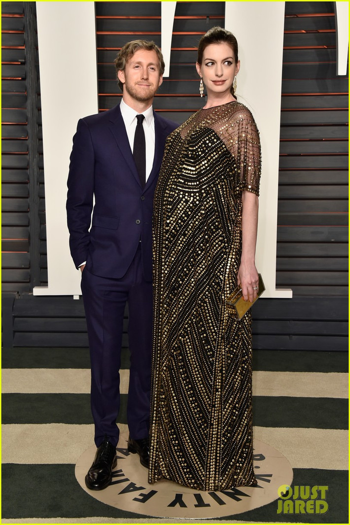 Dù bụng bầu vượt mặt nhưng Anne Hathaway vẫn tích cực đi dự tiệc vanity fair sau lễ trao giải Oscar cùng chồng. Nữ diễn viên mặc váy suông đính kim loại cầu kỳ.