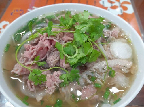 Khác với nước phở truyền thống, Phở 10 Lý Quốc Sư không trong vắt mà ngả vàng vừa có vị béo của các loại xương ninh lâu, vừa có vị ngọt thanh tự nhiên. Đặc biệt, bánh phở của quán được tự làm, màu trắng trong kết hợp với thịt bò tươi rói, đậm vị khiến thực khách ăn một lần sẽ nhớ mãi. (Ảnh: Tripadvisor)