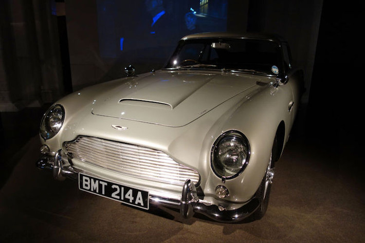 Aston Martin DB5 trong Goldfinger (1964): Mẫu xe dành riêng cho James Bond (Bondmobile) nổi tiếng nhất, và là chiếc đầu tiên được gắn các trang bị đặc biệt cho chàng điệp viên này bao gồm; súng máy giấu sau đèn xi-nhan, khiên chống đạn, biển số đổi được, trục bánh có cưa xé lốp...