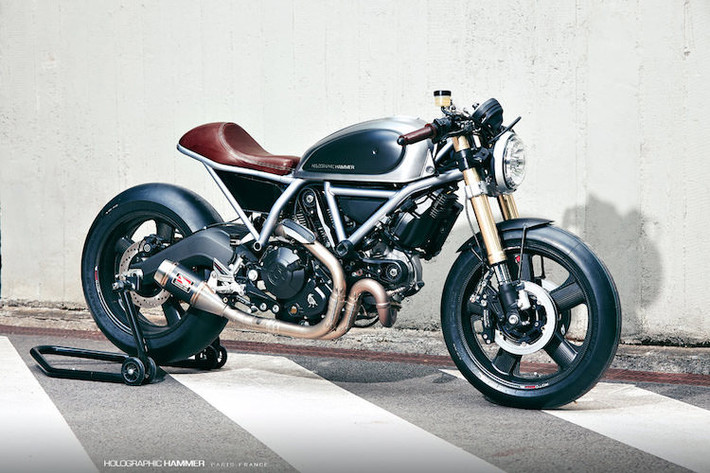 Ducati Scrambler Holographic Hammer: Là sản phẩm hợp tác giữa một cựu thiết kế của BMW, Ducati và tạp chí Moto Heroes, bản độ Ducati Scrambler nổi bật với kiểu dáng cafe racer thể thao và các phụ tùng "hàng hiệu" như mâm carbon Rotobox, phuộc USD Showa, phanh Beringer 4D...
