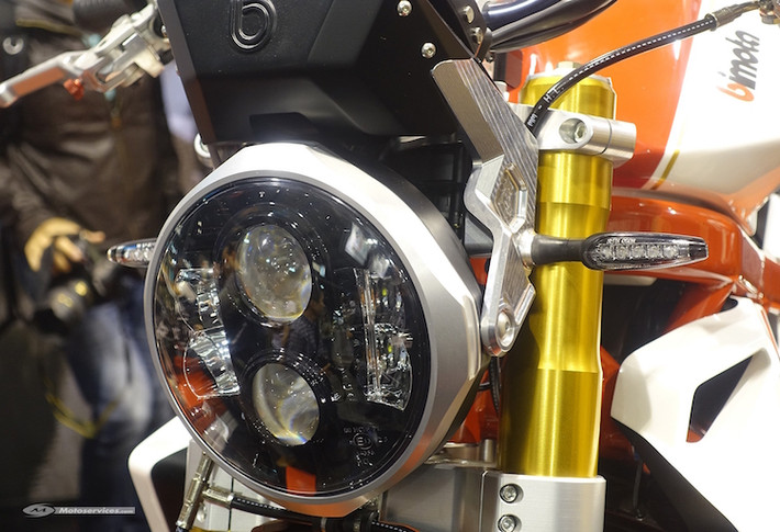 Thay vì phần đầu sắc nhọn của DB9, Impeto có đầu xe đơn giản hơn với một đèn pha LED với thiết kế tương tự nhiều mẫu xe Harley-Davidson. Ngay cả pát bắt đèn pha vào phuộc xe cũng được chế tác bằng công nghệ CNC từ nhôm nguyên khối.
