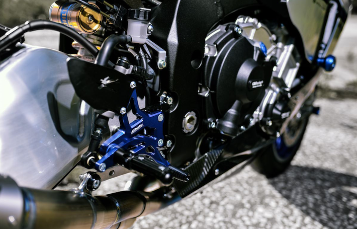 Dàn để chân nhôm CNC cũng do Valter sản xuất, với màu "xanh GP" truyền thống đúng chất Yamaha.