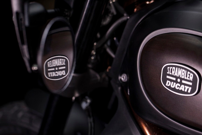 Gương chiếu hậu trên bản Scrambler thường đã được thay bằng gương gắn gù tay lái, đồng thời bình xăng xe có logo bằng kim loại đặc biệt mô phỏng hình dáng của một mắt kính râm.