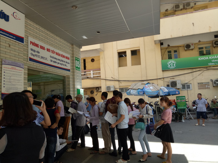 9h sáng, nắng đã bỏng rát, bệnh nhân chỉ dám đứng ở chỗ có mái che, có bóng râm... chờ đến lượt.