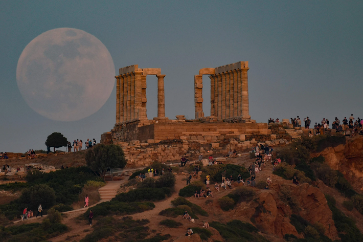 Người dân địa phương và du khách ngắm siêu trang máu bên Đền Peseidon ở Athens, Hy Lạp. Ảnh: AFP