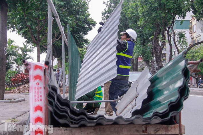 Các công nhân bắt đầu dựng rào quây 4km vỉa hè trên đường Láng.