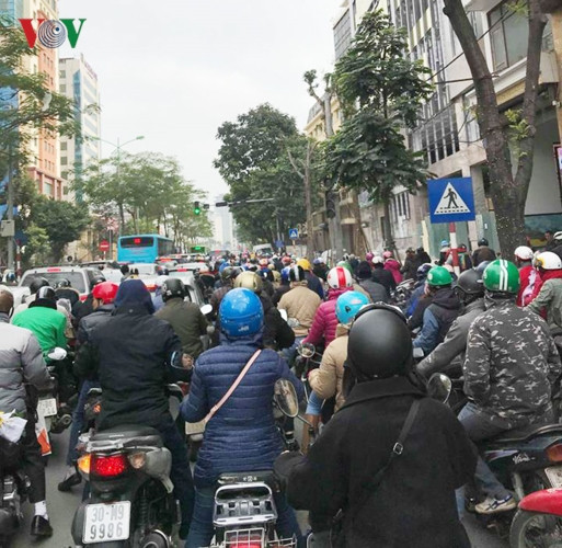 Dòng người và xe cộ nêm cứng ở trên đường.