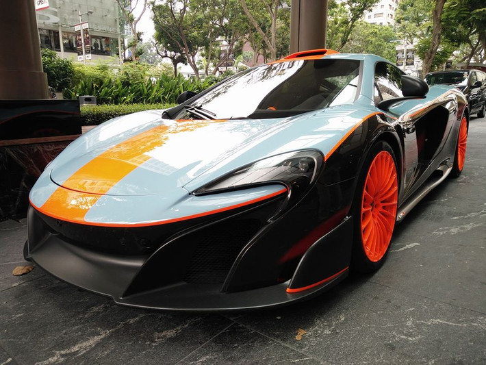 Siêu xe McLaren 675LT "hàng thửa" do chính Hoàng tử Malaysia, Tunku Idris Iskandar Ismail sở hữu vừa sang Singapore xem đua xe F1. Hình ảnh chiếc siêu xe này luôn là tâm điểm chú ý của mọi người tại trường đua ở đây.