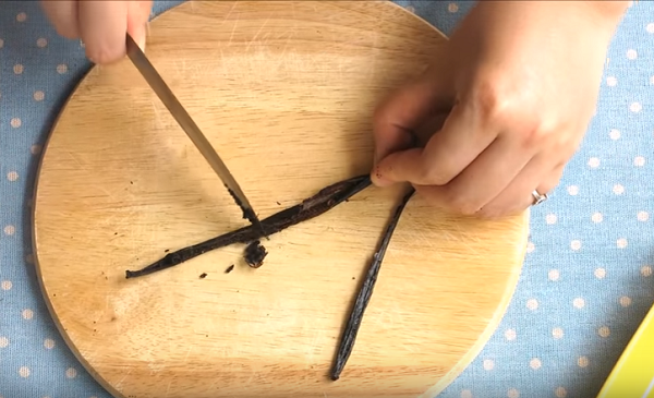 Bước 1: Cách làm vani thật dễ dàng. Trước tiên bạn dùng lưng dao làm mềm, dập quả vanilla rồi khía đôi theo chiều dọc. Sử dụng mũi dao gạt lấy hết hạt vanilla ra.