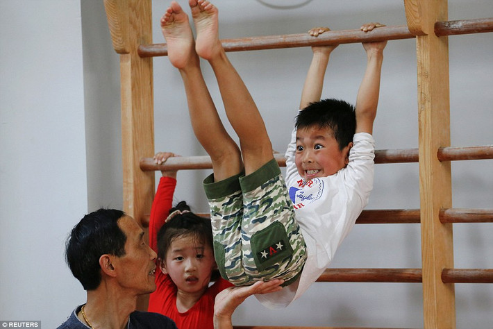 Khuôn mặt của VĐV nhí này đang phải nhăn nhó trong giờ tập thể dục dụng cụ.