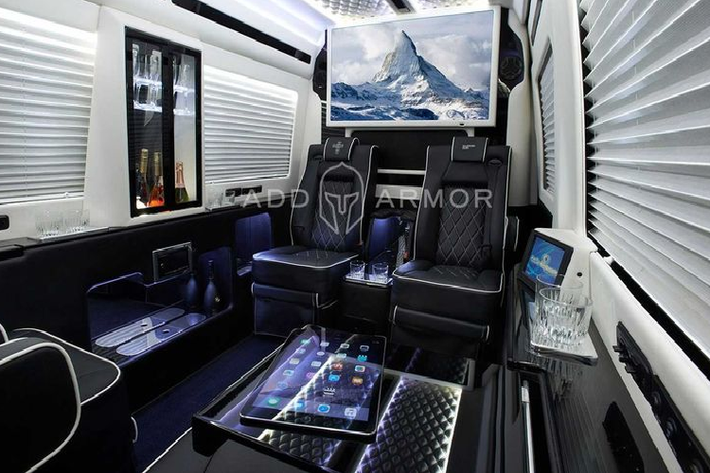 AddAromor cung cấp hai cách trang trí nội thất cho Sprinter, một gồm các ghế màu đen đi kèm đường chỉ khâu tương phản, sàn tối màu, đèn chiếu sáng màu xanh lam trên trần và một chiếc tủ gắn trên tường chứa những chai rượu sâm banh và ly.