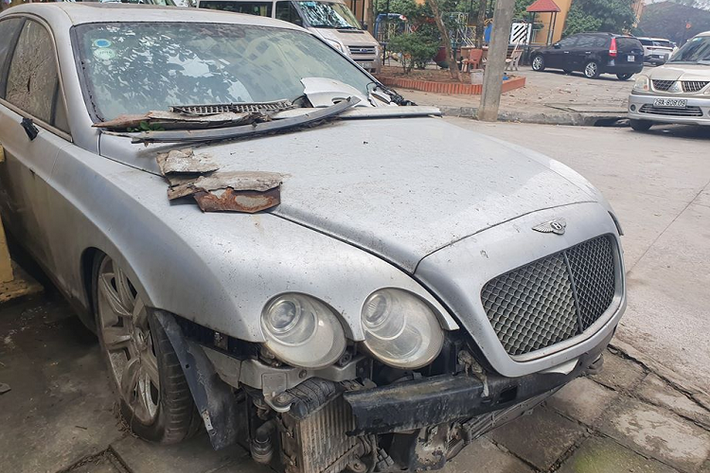 Một chiếc xe siêu sang Bentley Continental Flying Spur trong tình trạng vỡ nát phần vỏ đang nằm trên vỉa hè một con phố tại Hà Nội. Đối với giới thạo tin, không khó để nhận ra chiếc Bentley này từng xuất hiện trong một bãi gửi xe trong nhiều năm liền trước khi được đưa ra ngoài. Hiện chưa rõ lý do tại sao chiếc xe lại không còn nằm trong bãi nữa.