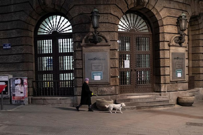 Một người phụ nữ dắt chó đi dạo trong giờ giới nghiêm ở Belgrade, Serbia, ngày 23/3.