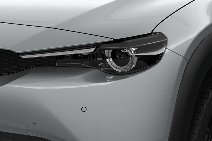 Ở phía trước, Mazda MX-30 có lưới tản nhiệt nhỏ dù phần động cơ điện bên trong chẳng cần làm mát. Hốc gió trên cản trước được chia đôi bằng một thanh nằm dọc. Nằm hai bên lưới tản nhiệt là cụm đèn pha LED và cụm đèn sương mù thanh mảnh đặt ở 2 góc cản va trước.