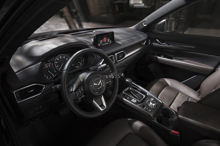 Ở bên trong, CX-5 Carbon Edition được trang bị ghế bọc da màu đỏ cùng các điểm nhấn màu đen tương phản trên bảng điều khiển, cửa... Vô-lăng và cần số được khâu chỉ đỏ nổi bật.