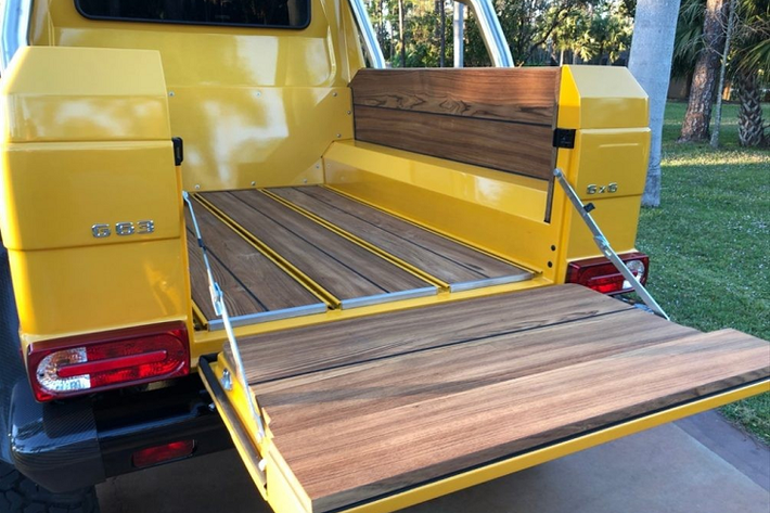 Vẻ đẹp hầm hố của "quái vật 6 chân" Mercedes-Benz G63 AMG 6x6 độc nhất Việt Nam nhìn từ phía sau. Chiếc xe này còn được trang bị hệ thống ống xả độ của hãng Akrapovic có giá lên đến 395 triệu đồng. Thảm sàn cho khoang hành lý phía sau trên "quái vật 6 chân" Mercedes-Benz G63 AMG 6x6 độc nhất vô nhị tại Việt Nam được ốp gỗ tếch.