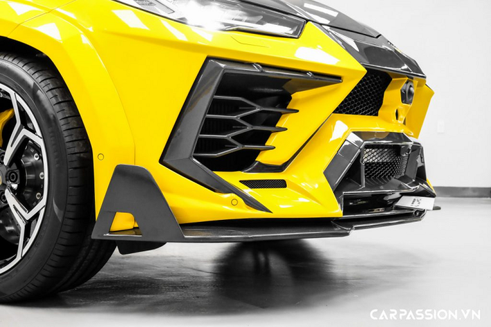 Sử dụng vật liệu sợi carbon, các chi tiết mới không chỉ cải thiện tính khí động học mà còn giúp Urus giảm đi cân nặng, đồng thời gia tăng hiệu năng vận hành. Đầu xe được trang bị thêm líp trước to bản bằng sợi carbon, nắp ca-pô nguyên bản trên xe cũng được thay thế hoàn toàn bằng nắp ca-pô carbon được dập gân mạnh mẽ, bổ sung thêm 4 khe thoát khí có tạo hình hầm hố. Gương chiếu hậu trên xe cũng được ốp sợi carbon và khắc tên của nhà độ nước Đức.