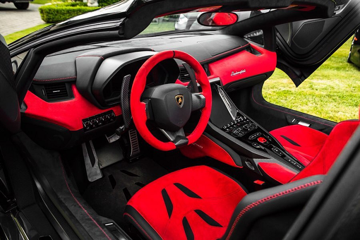 Bên trong chiếc Centenario Roadster nổi bật với màu đỏ của chất liệu da Alcantara trên ghế ngồi, bảng táp-lô, vô-lăng... Da Alcantara màu đen cũng được dùng ở một số chi tiết giúp tăng thêm sự nổi bật cho khoang nội thất.