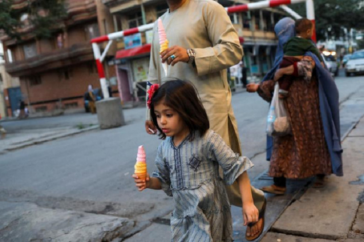 Bé gái Afghanistan cùng cha đi dạo trên đường phố