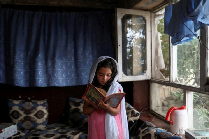 Bé gái Afghanistan chăm chú đọc sách