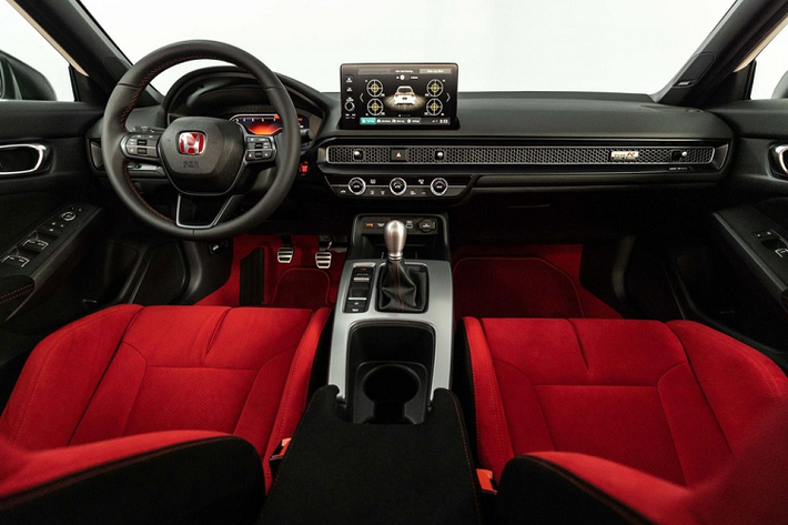 Bước vào bên trong Honda Civic Type R 2023, người lái sẽ choáng ngợp với màu đỏ rực rỡ ở ghế, thảm sàn, dây đai an toàn và logo trên vô lăng.