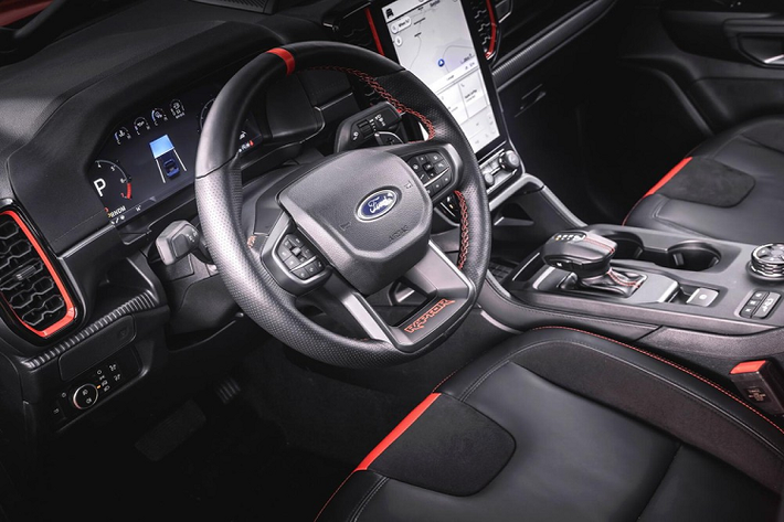 Bước vào bên trong Ford Ranger Raptor 2022, người lái sẽ tiếp tục thấy những thay đổi so với Ranger thông thường. Cụ thể, mẫu xe bán tải hiệu suất cao này được trang bị ghế thể thao, lấy cảm hứng từ máy bay chiến đấu, chỉ khâu màu đỏ, vô lăng bọc da cao cấp, có tính năng sưởi và tích hợp lẫy chuyển số cũng như hệ thống đèn viền.