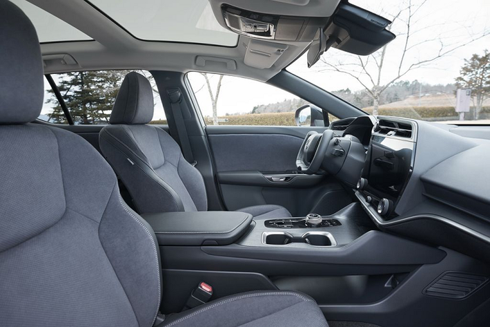 Bước vào trong cabin, Lexus RZ 450e 2023 chào đón người dùng bằng một không gian cao cấp và hiện đại. Điểm nhấn bên trong khoang lái của 450e 2023 là vô lăng kiểu dáng hình chữ nhật giống Tesla Model S và Model X. Tuy nhiên vô lăng kiểu này chỉ được cung cấp dưới dạng tuỳ chọn và vô lăng truyền thống vẫn luôn có sẵn nếu người dùng muốn. Phía sau vô lăng là bảng đồng hồ kỹ thuật số nhỏ gọn.
