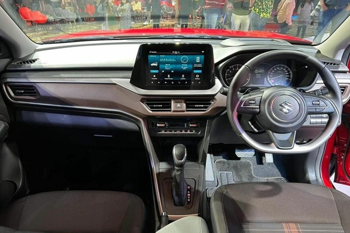 Không chỉ ngoại thất, hãng Suzuki còn thổi làn gió mới cho nội thất của Brezza. Bên trong xe, mẫu SUV hạng A này được trang bị mặt táp-lô phối 2 màu đen - nâu mới, gợi liên tưởng đến người anh em Suzuki Baleno 2022. Ngoài ra, trên mặt táp-lô và mặt cửa còn có những chi tiết ốp trang trí màu bạc tương phản. Ngay cả các nút bấm, vô lăng, bảng đồng hồ và màn hình thông tin giải trí của Suzuki Brezza 2022 cũng giống với Baleno mới.