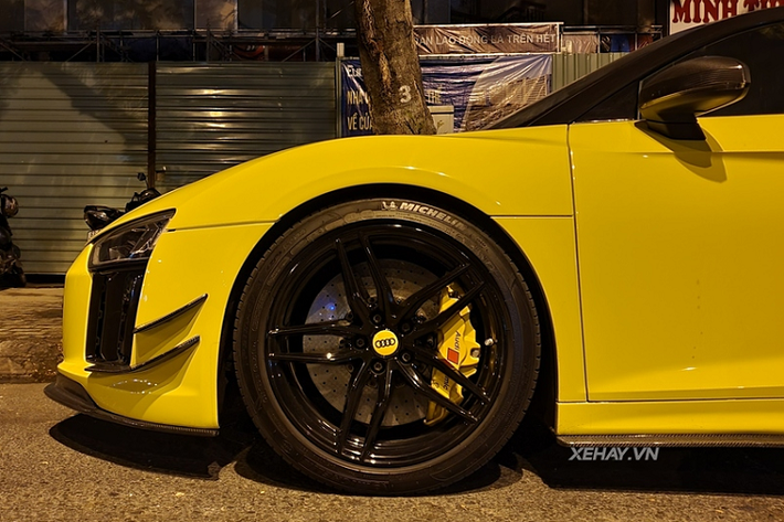 Chiếc Audi R8 V10 Plus màu vàng này được trang bị bộ mâm năm chấu kép sơn đen khá hầm hố, ẩn bên trong là đĩa phanh carbon ceramic kết hợp với cùm phanh sơn vàng tương tự lớp decal ngoại thất. Tương tự như cản trước đuôi xe cũng được làm mới với thiết kế cứng cáp.
