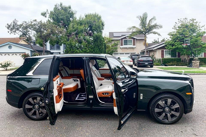Ở giữa hai hàng ghế của xe Rolls-Royce Cullinan màu sơn Dark Emerald có bệ tỳ tay, tủ lạnh, hai chiếc ly và rượu champagne cùng một số tuỳ chọn khác. Phía sau hàng ghế thương gia này còn có một tấm kính để ngăn cách với khoang hành lý.