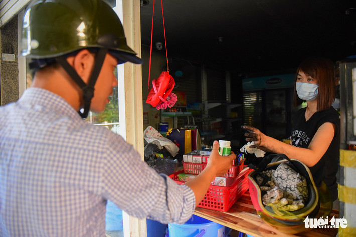Trong tiệm tạp hóa, hàng hóa bám đầy khói bụi, thế nhưng họ vẫn tranh thủ bán hàng, gỡ được đồng nào hay đồng đó.