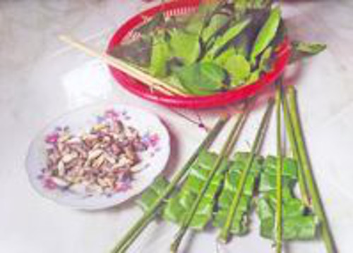 Nhộng ong nướng lá nhàu. Gói nhộng ong vào lá nhàu rồi đem nướng trên lửa than. Khi nhộng bốc hơi thơm lừng là đã chín. Nước chấm cho món ăn rất dân dã, muối tiêu chanh hoặc nước mắm ớt. Món ăn có vị béo ngọt hòa quyện với hương lá nhàu, chua cay mặn mặn của muối tiêu chanh. Ảnh: hanoilive