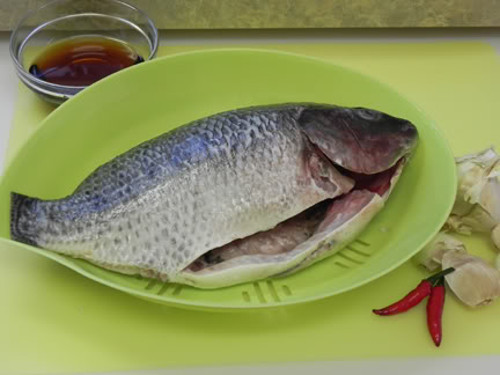 Cá luộc nhồi lá đinh lăng có vị thơm ngon, rất dễ ăn. Cá bỏ ruột, để nguyên con. Ướp cá với gia vị và sả, giềng. Nhồi lá đinh lăng thái nhỏ và chút lá thì là vào bụng cá. Rải phần thì là xuống dưới nồi gang. Ảnh: photobucket