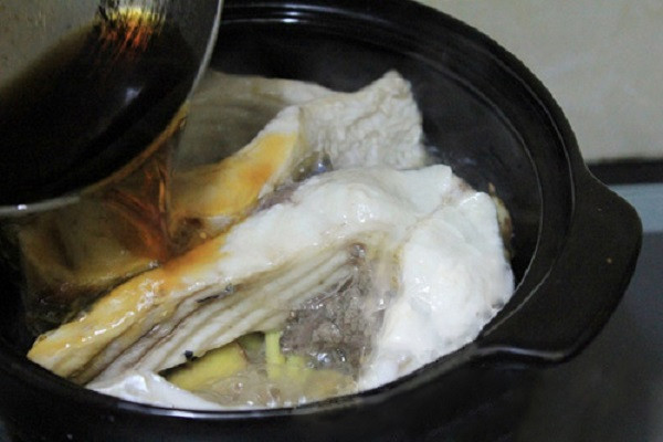 Cho phần nước màu vừa làm vào nồi cá kho, khuấy nhẹ tay phần nước kho để thịt cá ngấm đều. Cho thêm nước vào ngập mặt cá. Lưu ý một điều là phải dùng nước sôi, nếu dùng nước lạnh cá sẽ tanh. (Ảnh:webnauan.net)