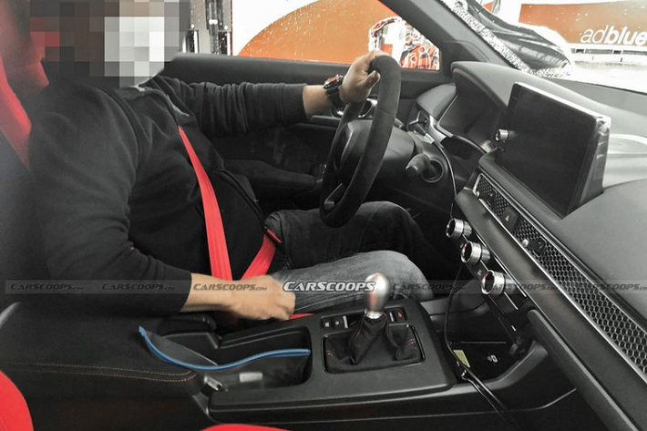 Tất nhiên, Civic Type R 2022 cũng sở hữu một số chi tiết thể thao hơn bản thường, ví dụ như các ghế thể thao màu đỏ, có logo “Type R” trên tựa đầu, dây đai an toàn màu đỏ và đường khâu tương phản màu đỏ trên bảng điều khiển trung tâm.