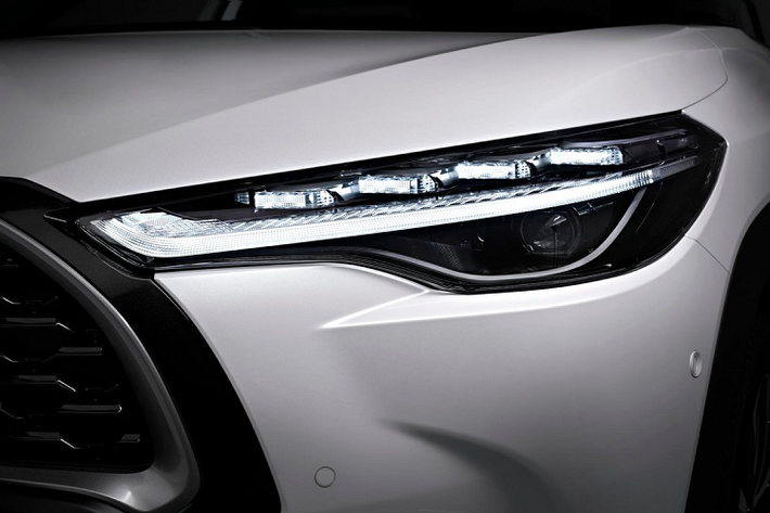 Bên ngoài, mẫu xe SUV Toyota Corolla Cross 2022 sở hữu thiết kế ngoại thất như sự kết hợp giữa xe ở Việt Nam và Nhật Bản. Theo đó, xe cũng được trang bị lưới tản nhiệt trên cỡ lớn với viền màu bạc và màu đen xung quanh. Bên dưới là hốc gió trung tâm khá rộng, tích hợp 2 đèn sương mù nhỏ hình tròn. Ngoài ra, hốc gió trung tâm còn được bao quanh bằng nẹp màu đen dày dặn, giúp tách riêng chi tiết này và lưới tản nhiệt. Những chi tiết này không có gì khác so với xe ở Việt Nam.