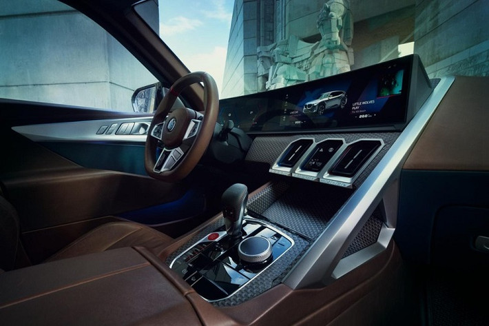 Hàng ghế phía sau của BMW XM lại có cách tiếp cận khác biệt hoàn toàn so với ghế lái, mang đến trải nghiệm như phòng chờ thương gia với kiểu ghế băng bọc da đen và nhung xanh lam. Trần xe có cấu trúc lăng kính ba chiều khá thú vị, tích hợp hệ thống đèn chiếu sáng đem lại một không gian nội thất đầy màu sắc và sống động.