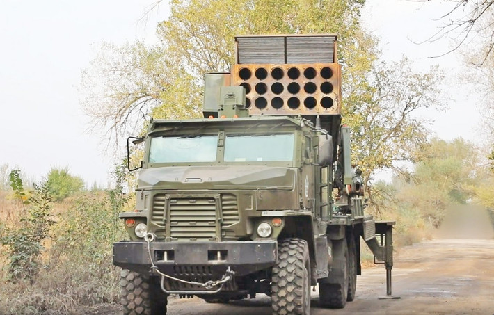 Về vũ khí của TOS-2, hệ thống này được trang bị 18 ống phóng có tầm bắn tối đa là 20 km. Phương tiện này được trang bị hệ thống nhắm mục tiêu tự động, cần cẩu tích hợp để nạp đạn và các yếu tố thiết kế nhằm giảm thiểu khả năng bị tấn công bởi vũ khí dẫn đường chính xác. Ảnh Defense Express