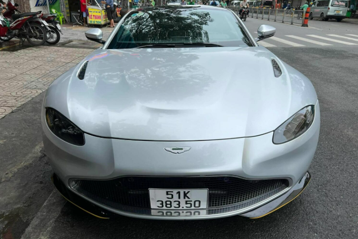 Aston Martin Vantage 007 Edition của Qua Vũ được khoác lên mình lớp decal màu bạc cùng chữ “UN” đặc trưng. So với Aston Martin Vantage tiêu chuẩn đang có mặt tại Việt Nam, phiên bản “điệp viên 007” có một số điểm khác biệt ở thiết kế ngoại thất.