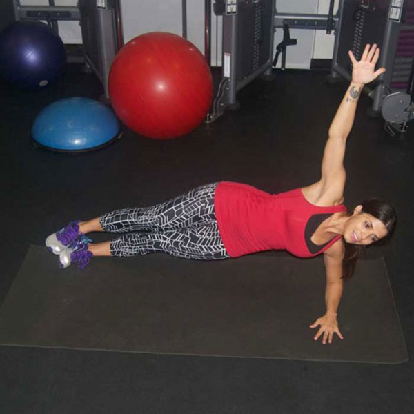 Động tác 5: Tạo dáng bài tập Plank cho nữ một bên với cẳng tay trên thảm và cùi chỏ dưới vai. B – Có kiểm soát, hạ hông phải xuống thảm, cách mặt sàn vài centimet. Sau đó đẩy ngược lên lại vị trí ban đầu và lặp lại, thực hiện 12-15 lần lặp trước khi đổi bên. Ảnh: khoedep.vn