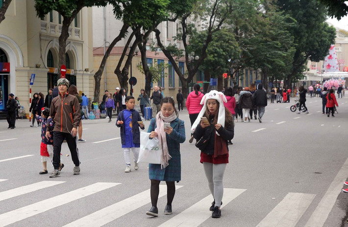 Người dân tại Hà Nội dạo chơi trên phố đi bộ Hồ Hoàn Kiếm đều trang bị cho mình quần áo ấm, quấn khăn, đeo khẩu trang… để chống lại thời tiết lạnh buốt.