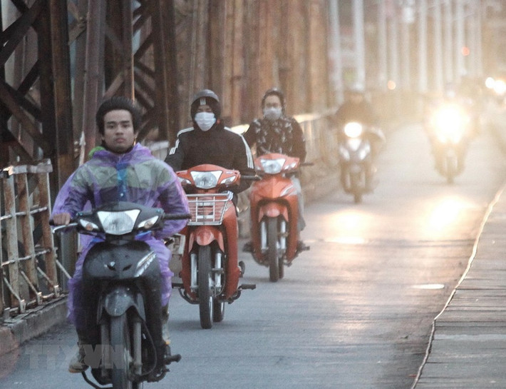 Người dân phải bịt khẩu trang, mặc áo mưa khi lưu thông qua cầu Long Biên sáng sớm.