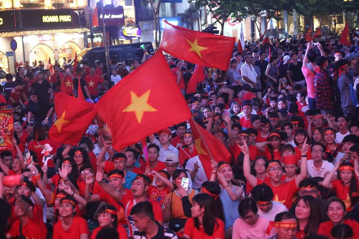 Cờ đỏ sao vàng được dơ cao, tung bay trong bóng đêm
